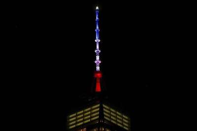 Iconic One World Trade Center and CN Tower spire lit blue, white and red in solidarity with France