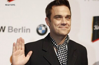 Robbie Williams performs with nude models